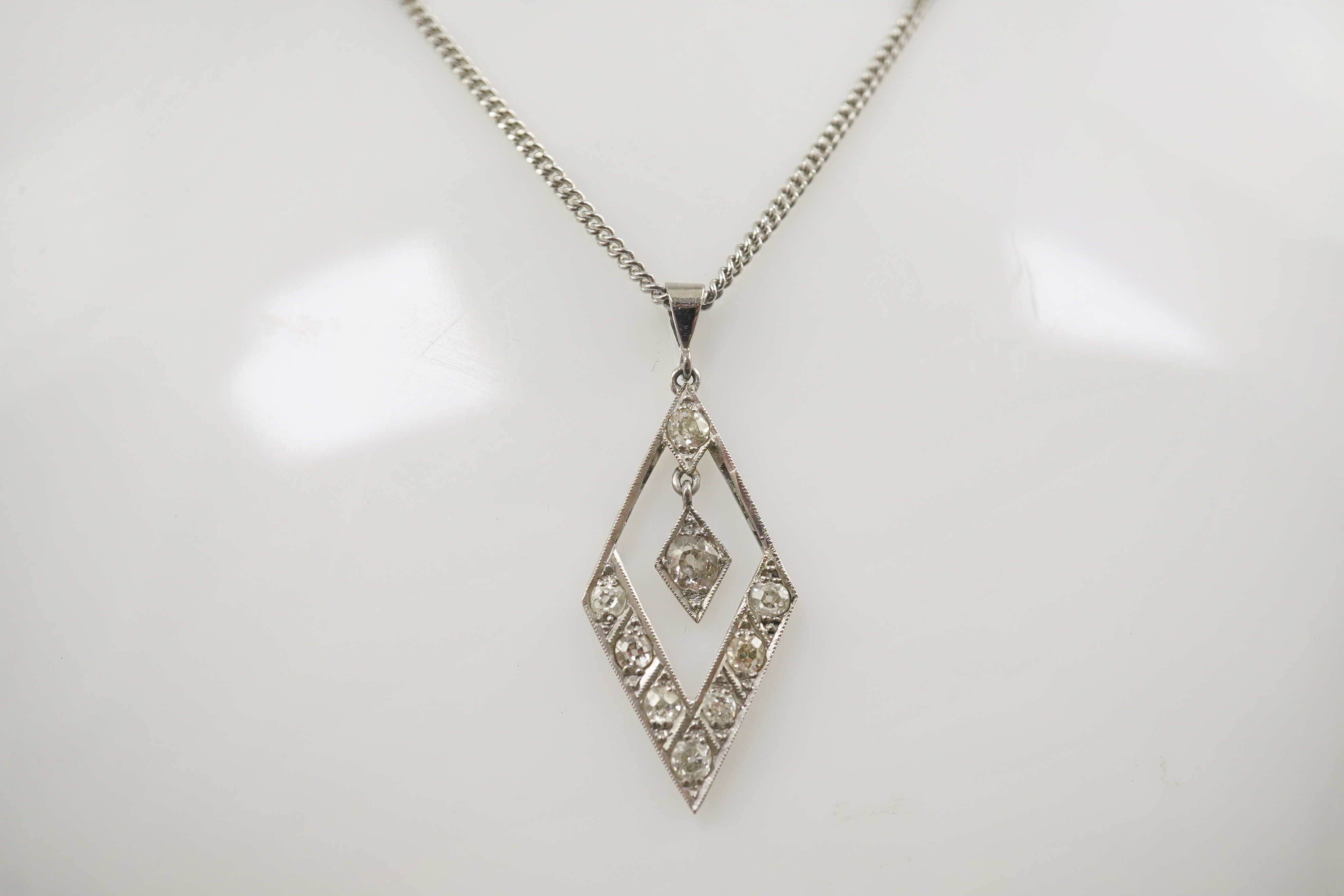 A 1940's white gold? and millegrain set diamond cluster drop pendant